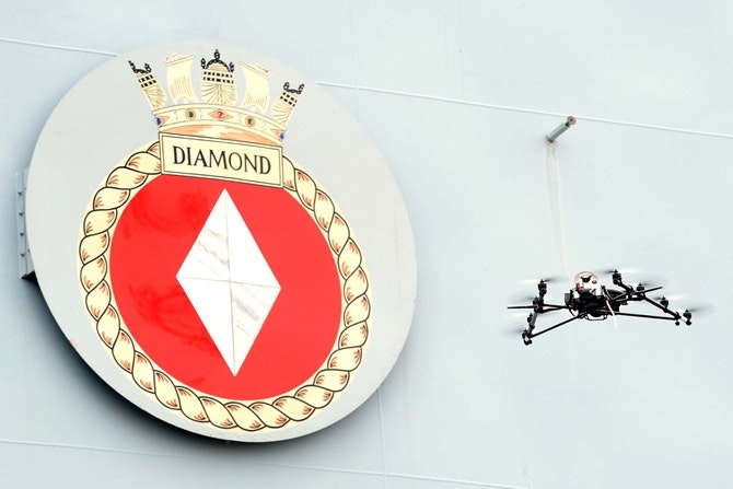 Drone flying in front of HMS Diamond nameplate
